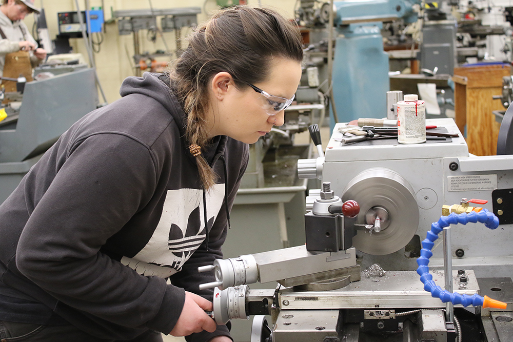 woman working on machining equipment