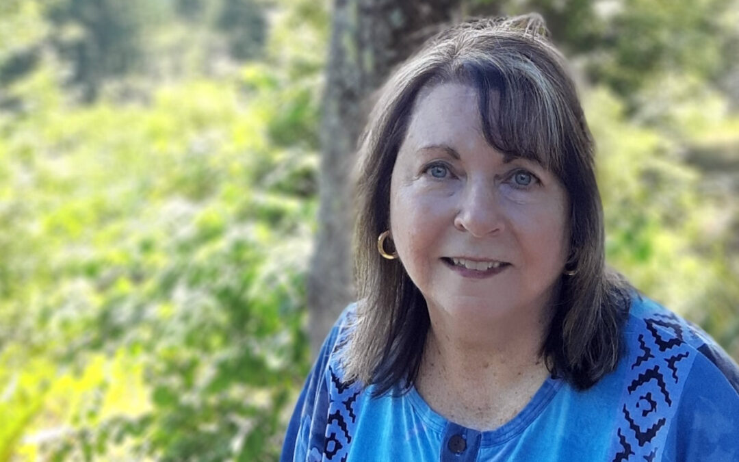 woman looking at camera, trees in background