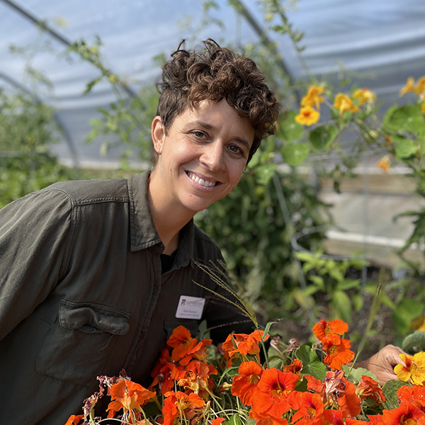image of woman smiling and some orange flowers