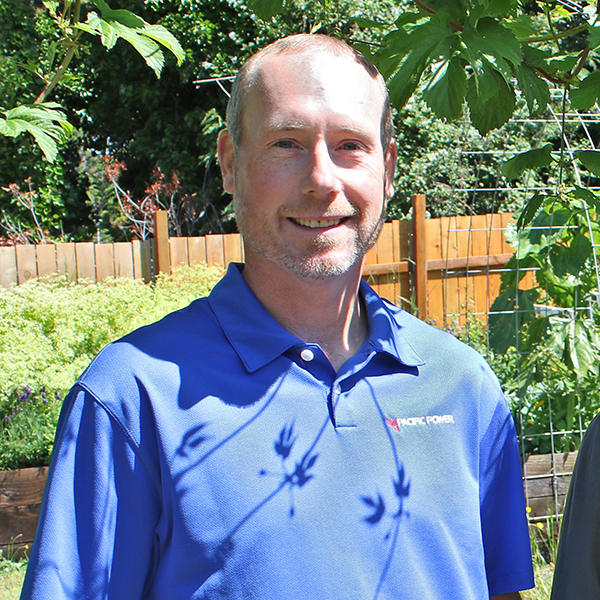 image of man smiling at camera with garden in background