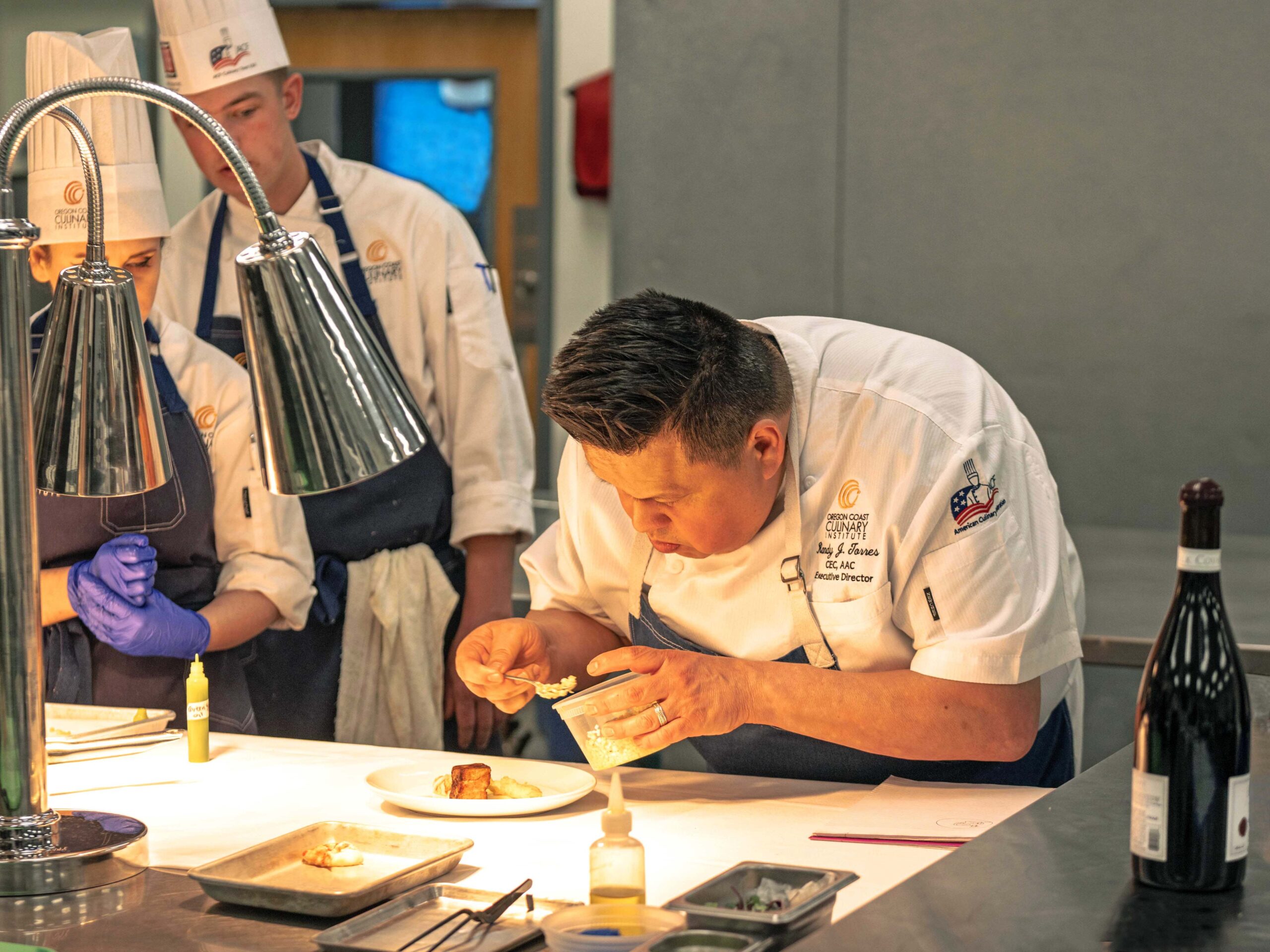 OCCI executive chef randy torres demonstrates plating to student chefs in preparation for the winemakers dinner