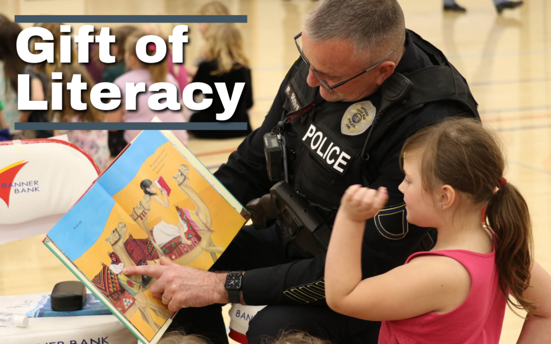 image of a male police officer reading a book to a little girl