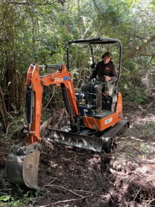 image of a man running heavy equipment digging dirt