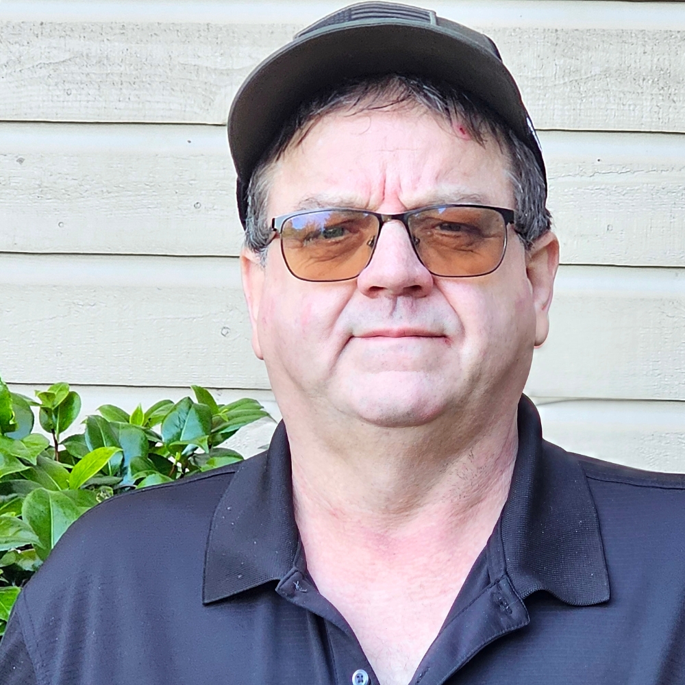 Terry Cheyne SQ Profile image of Diesel Mechanic Instructor Terry Cheyne standing outdoors in front of gray siding