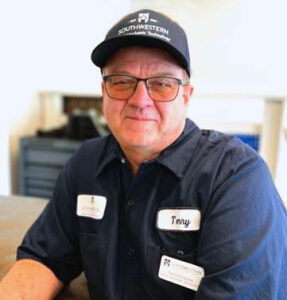 photo of middle-aged man in dark blue mechanic uniform with college logo and nametag saying Terry