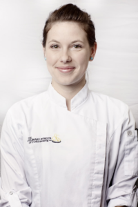 Portrait of Chef Maddie Sharp standing indoors against a white background