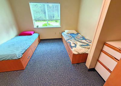 image of bedroom with two beds and one large window